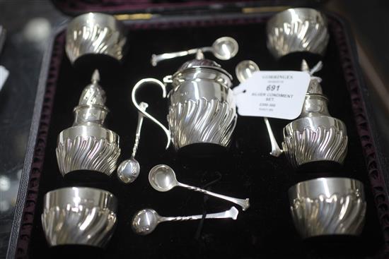 A cased Victorian repousse silver seven piece condiment set by James Deakin & Sons Ltd,